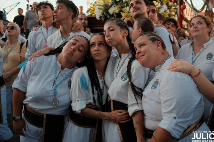 Young participants in white gather beside a religious float during the July Fiestas procession