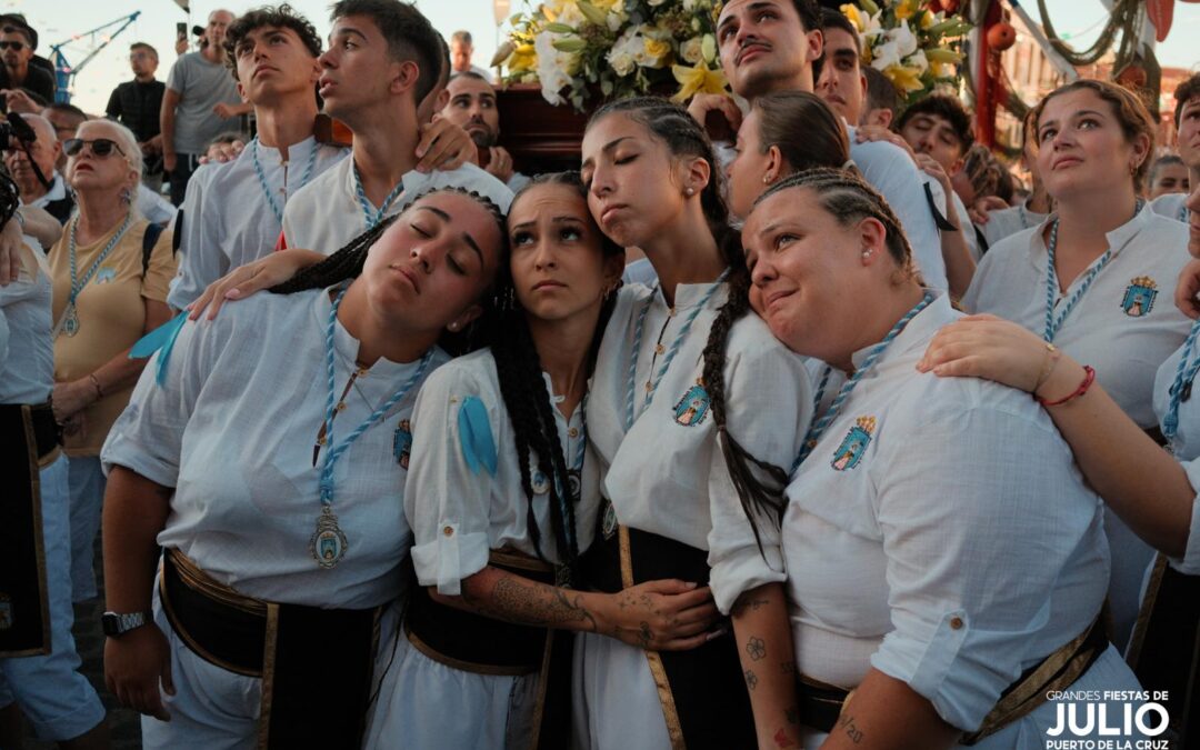 Young participants in white gather beside a religious float during the July Fiestas procession