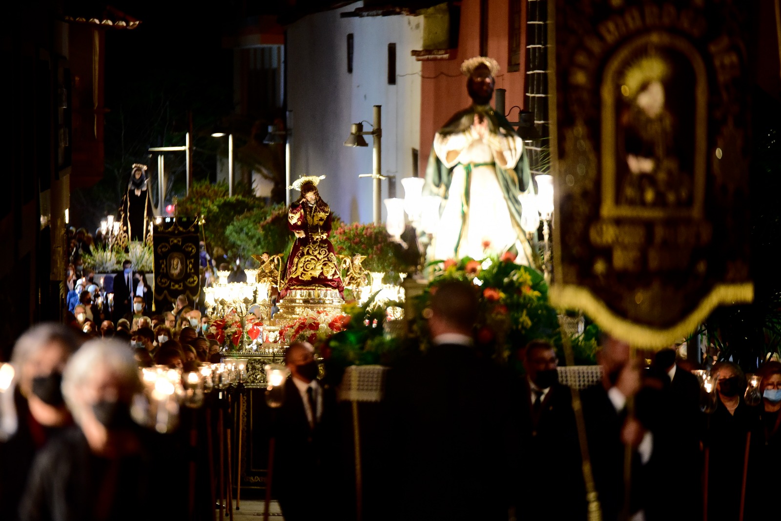 Several religious images and brotherhood participants in a night procession in Puerto de la Cruz in 2022