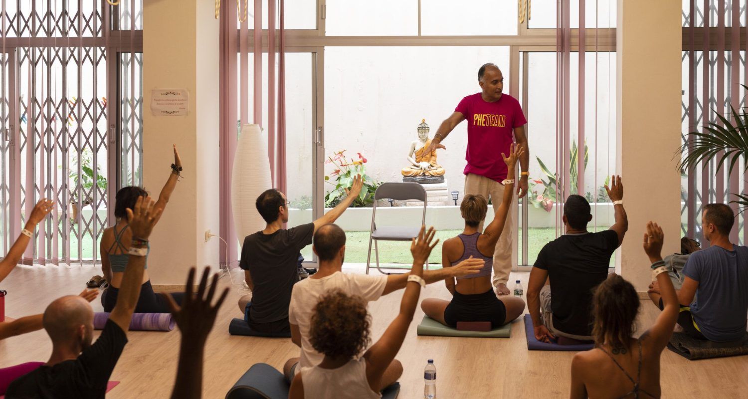 Instructor guiding participants seated on mats during a Phe Yoga session in 2024