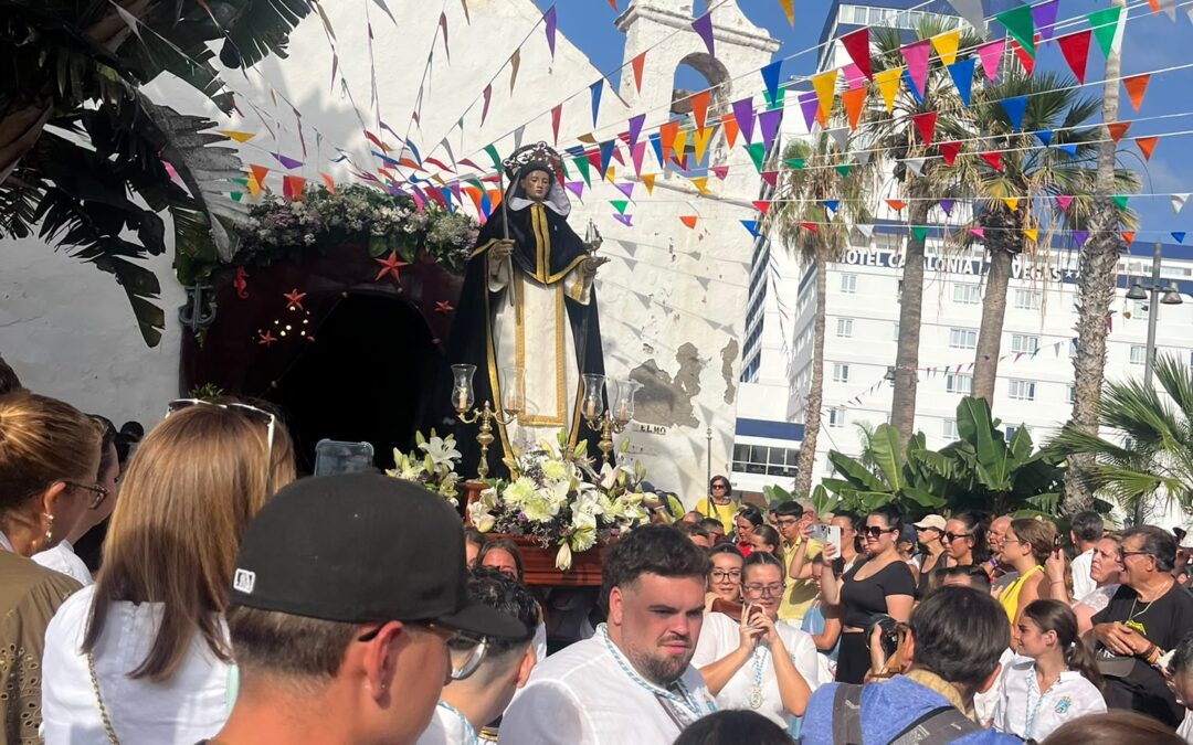 San Telmo statue carried outside the white chapel beneath bunting during the 2026 July Fiestas