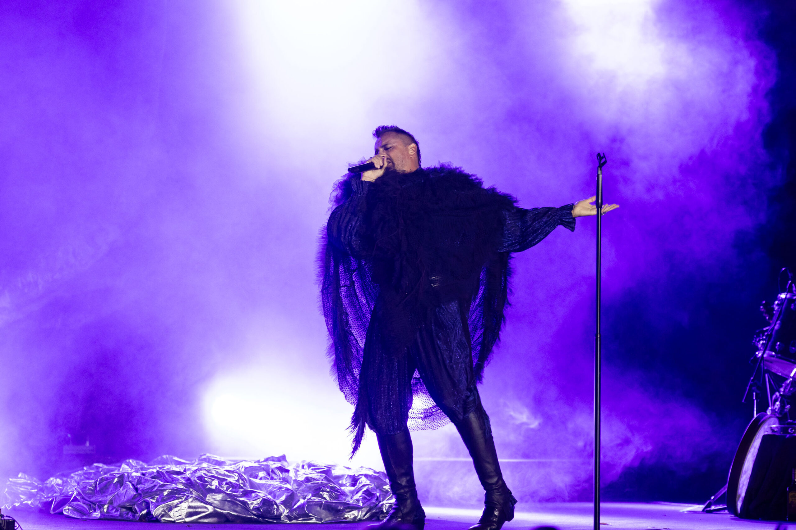 Singer performing in purple light at Veranos del Taoro
